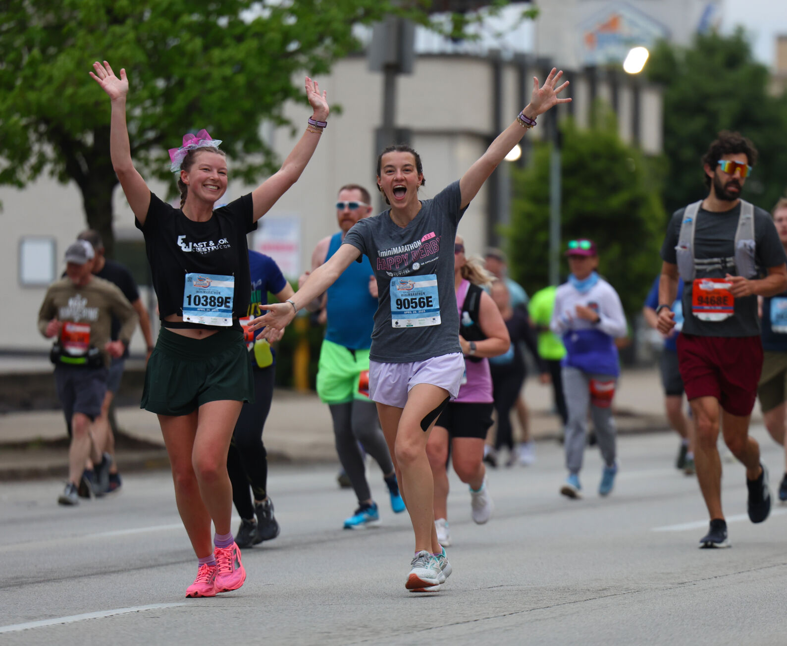 People wave as they run during Marathon.JPG